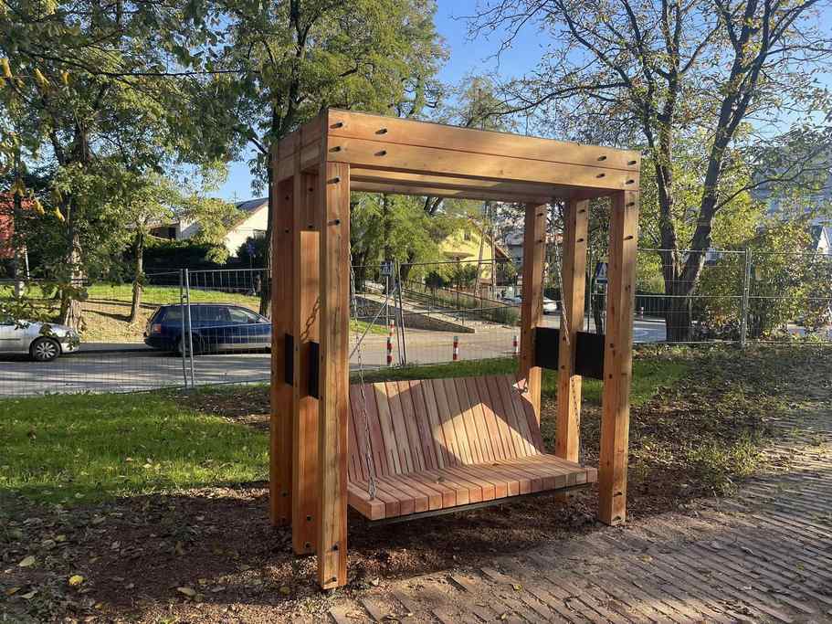 Ładna bujana ławeczka z drewna w parku